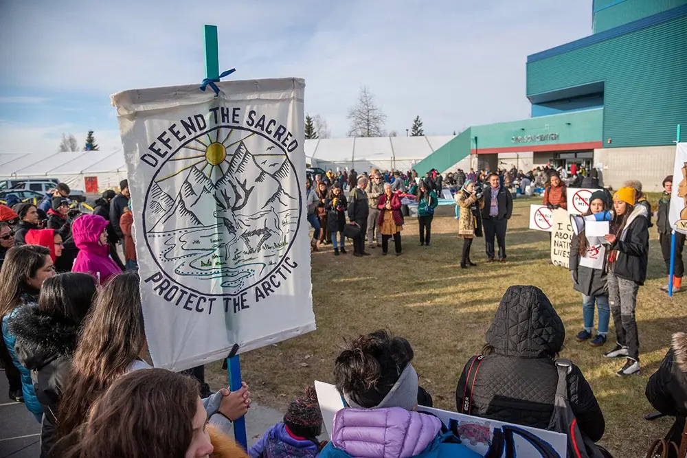 Native Movement members holding sign that read Defend the sacred. Protect the arctic.